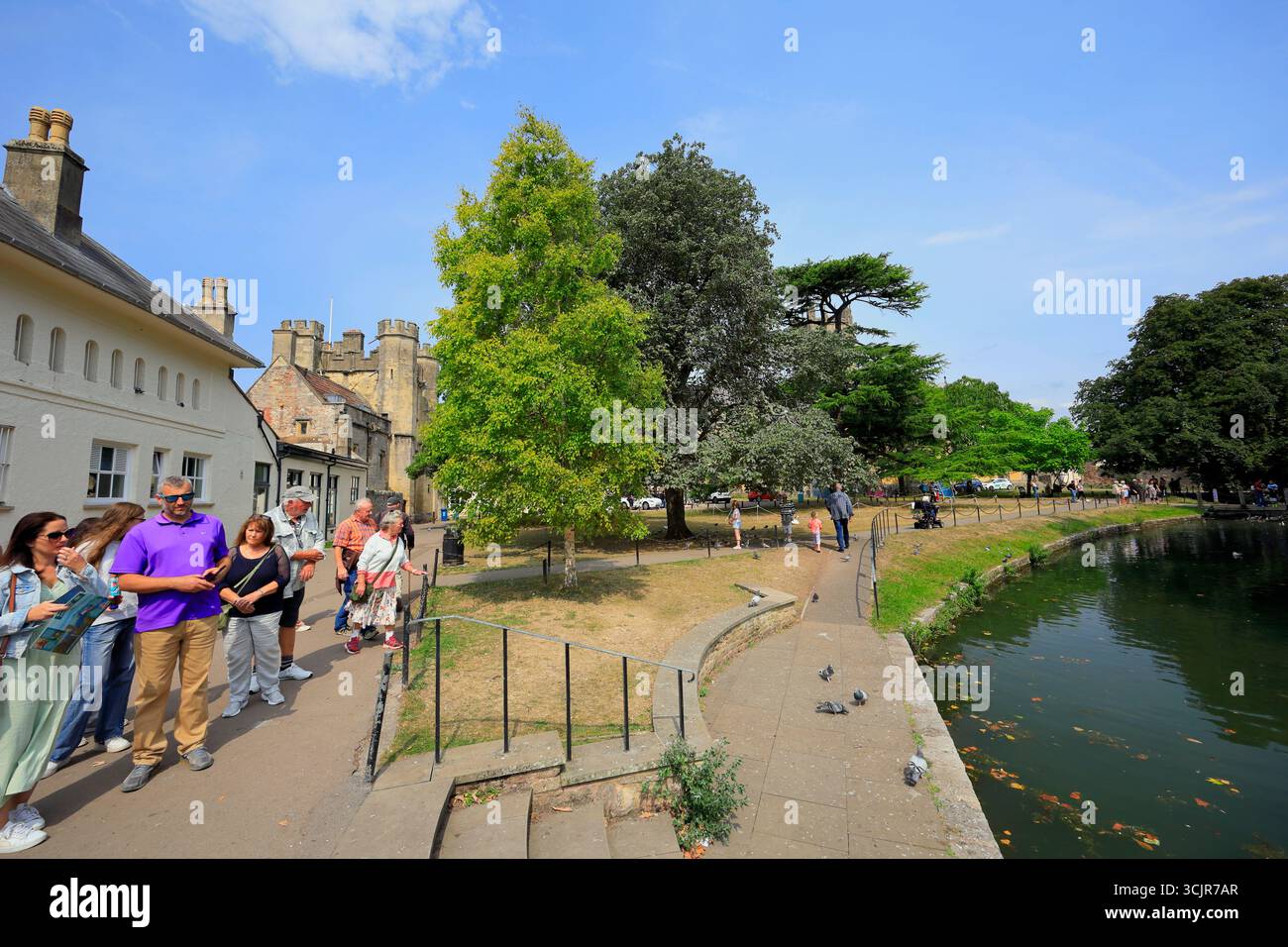 Touristen neben Bischops Palace Moat, Wells, Somerset. Stockfoto