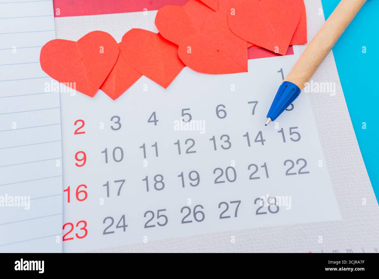 Schreiben Sie Notizen in ein Notizbuch mit einem Stift für einen Geschäftsplan, lieben Sie das, was Sie mit einem Kalender machen, und erstellen Sie eine Liste der täglichen Finanzen für den Valentinstag. Stockfoto
