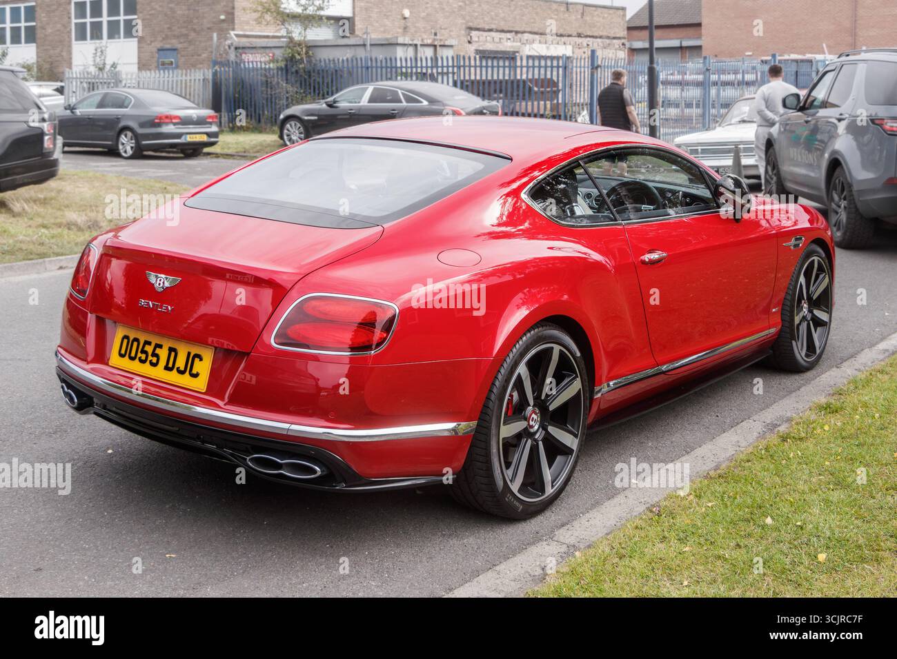 Rückansicht des glänzend roten Bentley Continental GT auf einer Straße mit anderen Autos und Gebäuden im Hintergrund Stockfoto