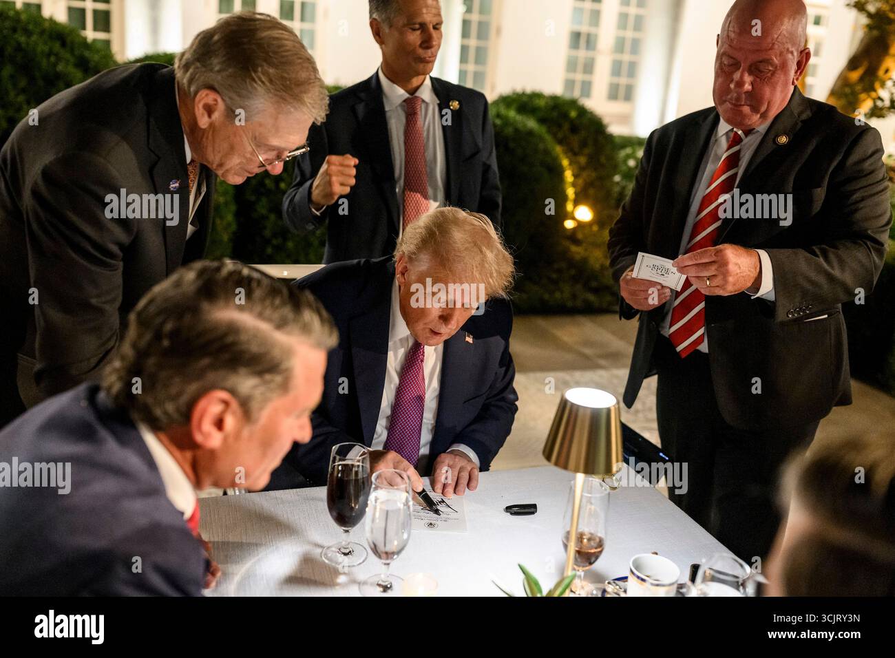Washington, Usa. September 2025. Mitglieder des Kongresses drängen sich um US-Präsident Donald Trump, Center, während er eine Einladung während der ersten Veranstaltung im Rose Garden, seit sie mit Pflastersteinen im Weißen Haus bedeckt, am 5. September 2025 in Washington, D.C. autographiert. Credit: Daniel Torok/White House Photo/Alamy Live News Stockfoto