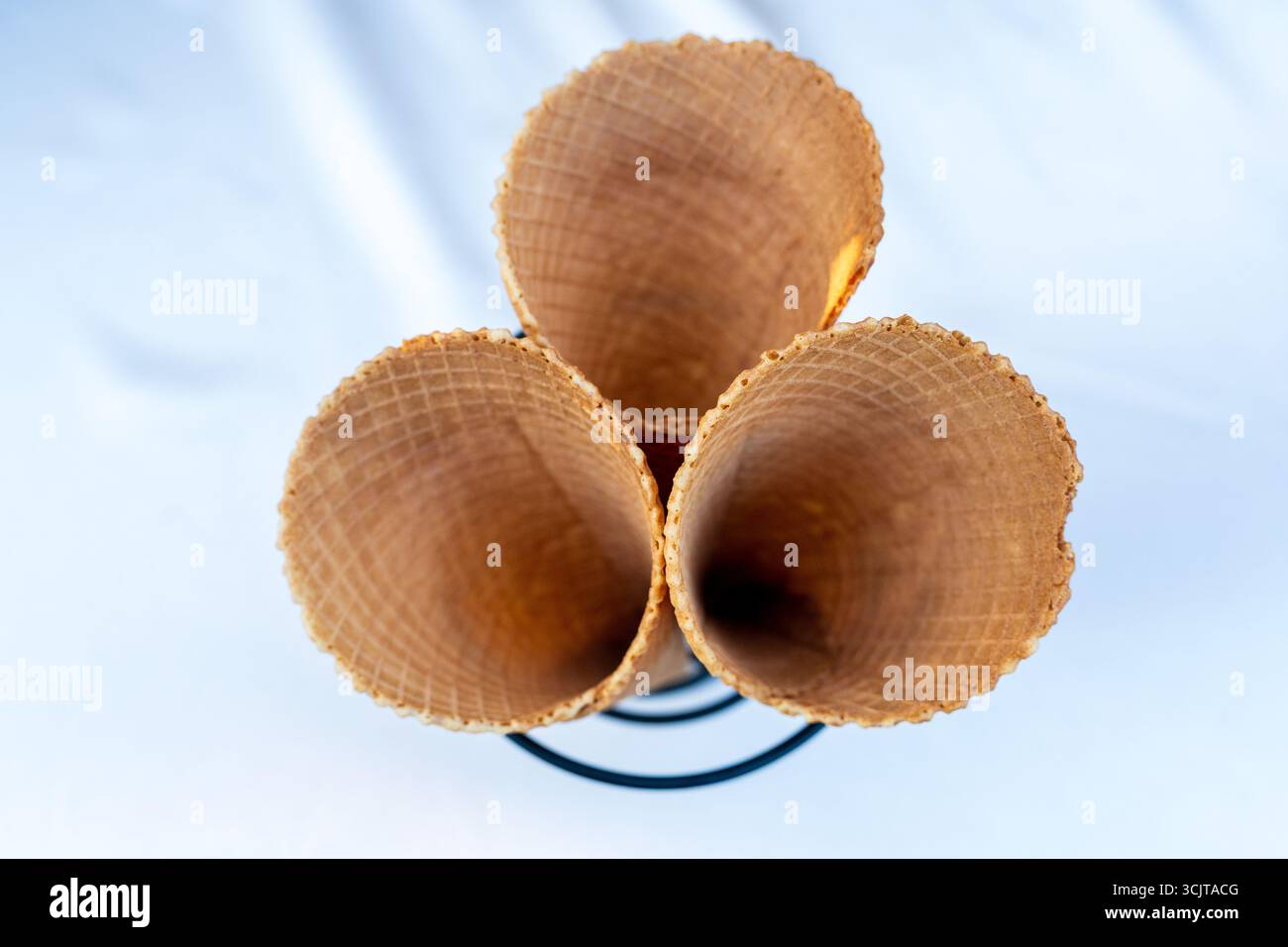 Drei leere braune Eiskegel auf dem weißen Tisch Stockfoto