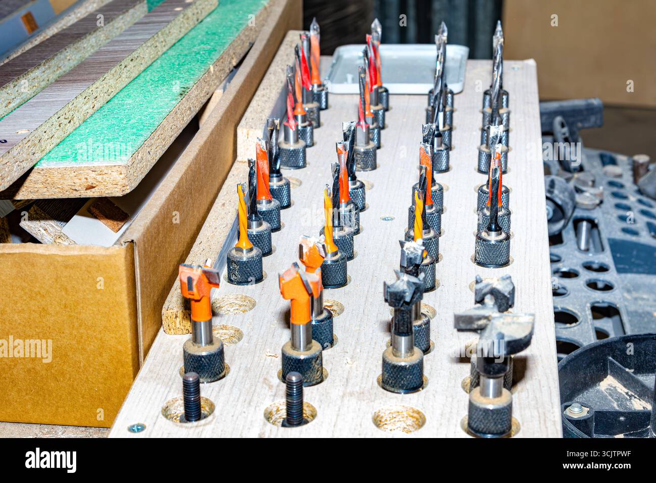 Fräsbits in Industriequalität mit verschiedenen Profilen und Durchmessern, angeordnet in einem kundenspezifischen Holzhalter für effizientes Werkzeugmanagement und schnellen Zugriff auf die Dauer Stockfoto