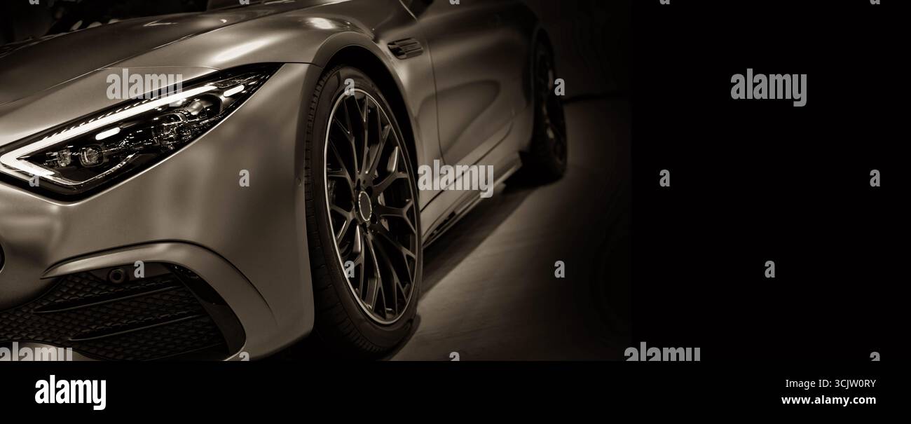 Vorderansicht der LED-Scheinwerfer des Sportwagens auf schwarzem Hintergrund in Sepia getönt Stockfoto