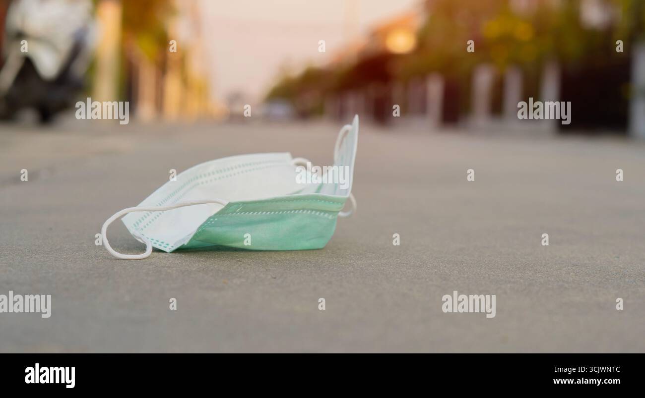 Higienische Maske auf dem Boden. Hygienemaske zum Einmalgebrauch. Konzeptionelle Hygiene. Nahaufnahme, Kopierbereich. Stockfoto