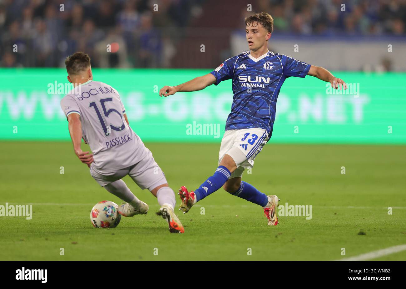 Schalke, Deutschland. August 2025. firo : 23.08.2025, Fußball: 2.Bundesliga FC Schalke 04 - VfL Bochum Vitalie Becker vom FC Schalke 04 spielt den Ball Einzelaktion gegen Felix Passlack vom VfL Bochum Credit: dpa/Alamy Live News Stockfoto