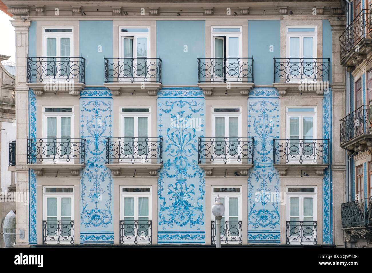 Traditionelle portugiesische Gebäudefassade mit blauen Azulejo-Fliesen in Porto. Europäische Architektur, Historische Fliesen, Balkone, Wohnfassade Stockfoto