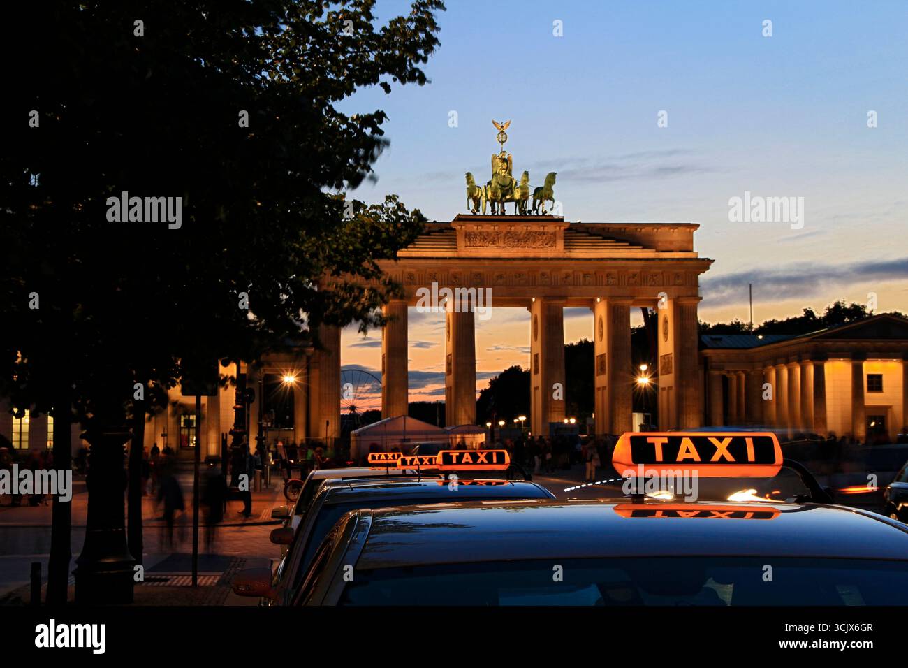 berlin - das brandenburger Tor am pariser Platz mit Taxifahrzeugen, die zur blauen Stunde in einer Warteschlange für Touristen-Passagiere warten Stockfoto