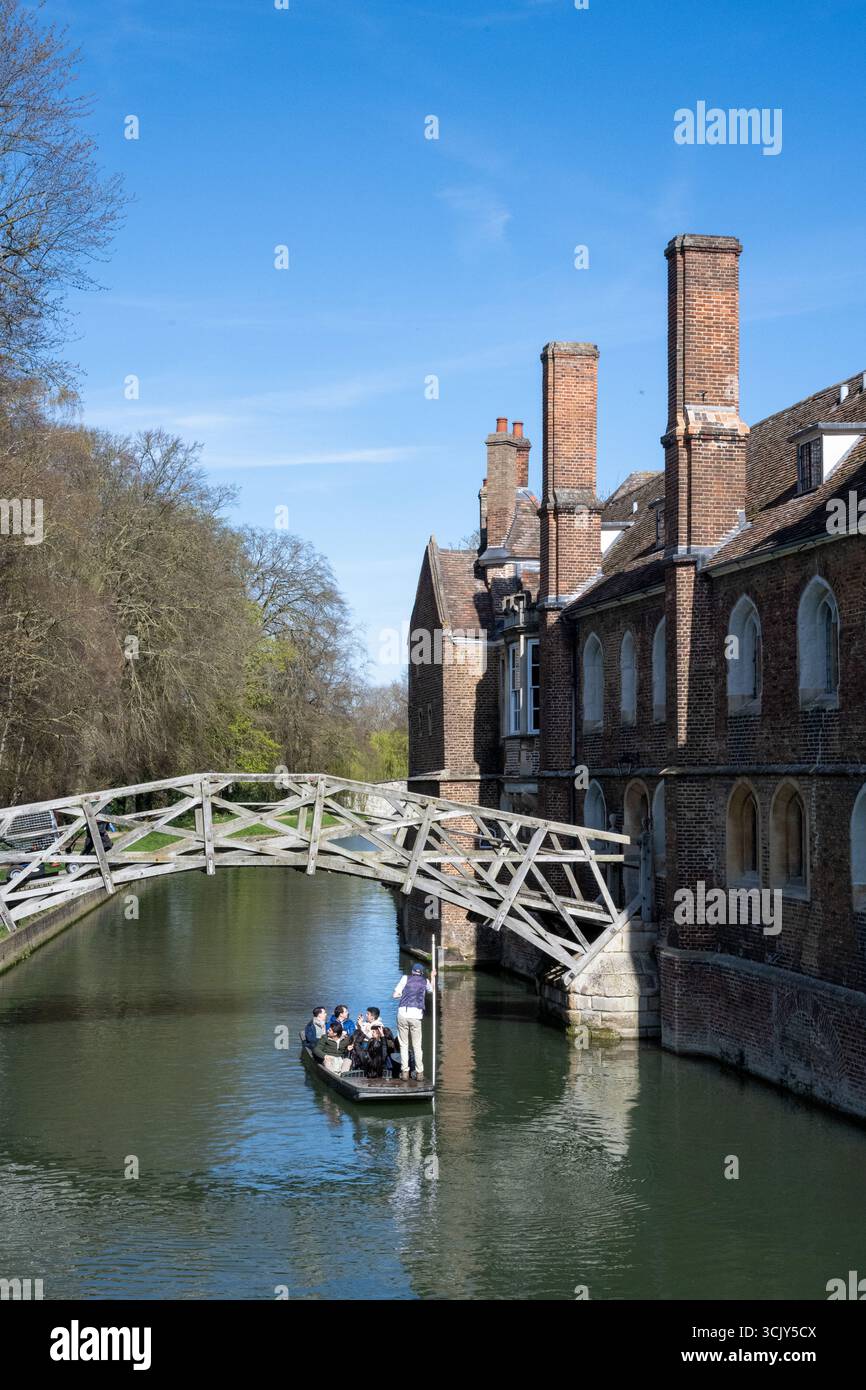 Touristen peitschen unter der Mathematical Bridge am Queens' College, Cambridge, und genießen einen hellblauen Frühlingstag auf dem Fluss Cam Stockfoto