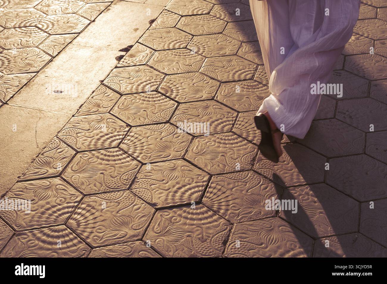 Fußgängerschatten auf den malerischen Fliesen von Barcelona am Abend Stockfoto