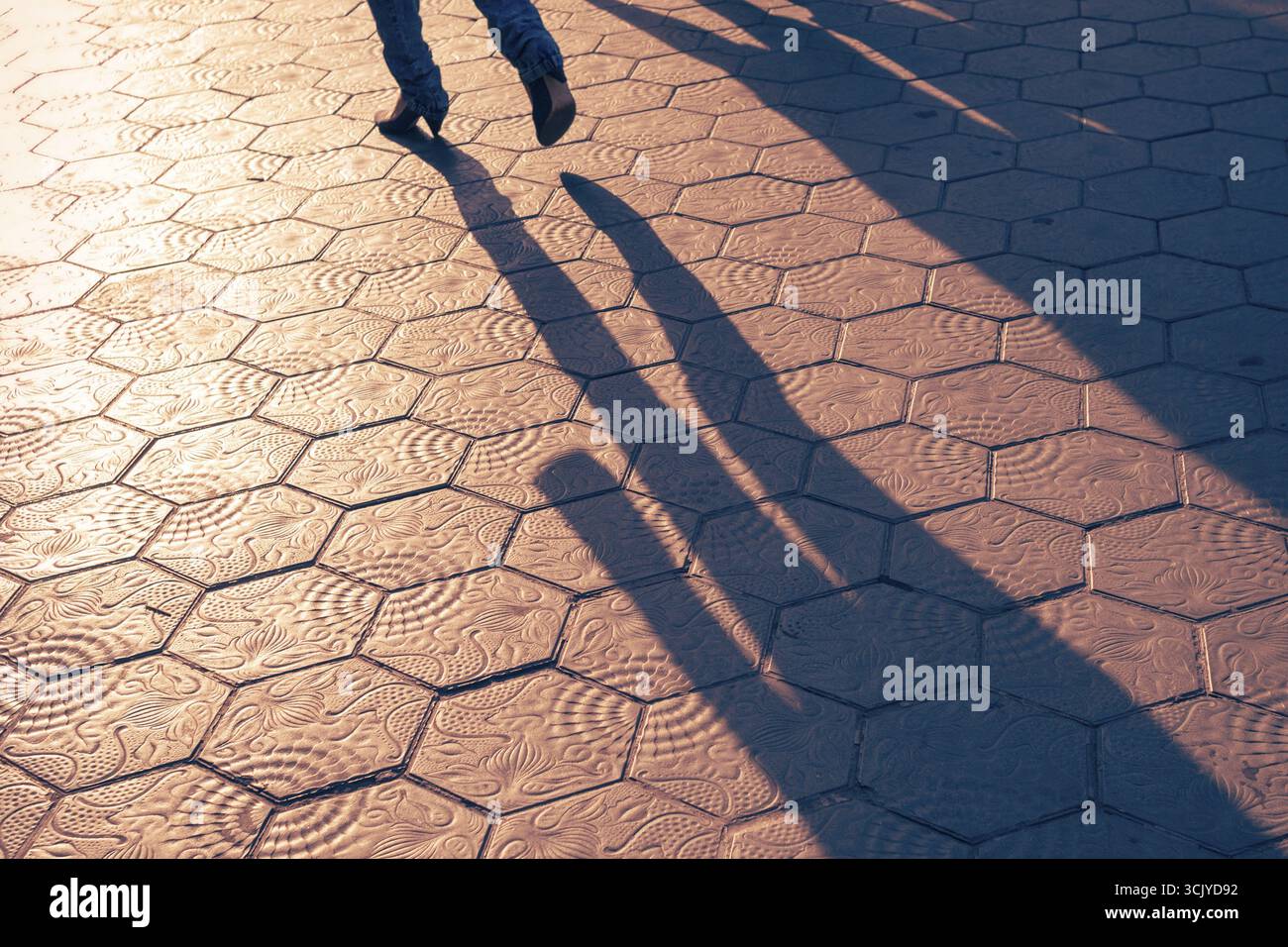 Fußgängerschatten auf den malerischen Fliesen von Barcelona am Abend Stockfoto