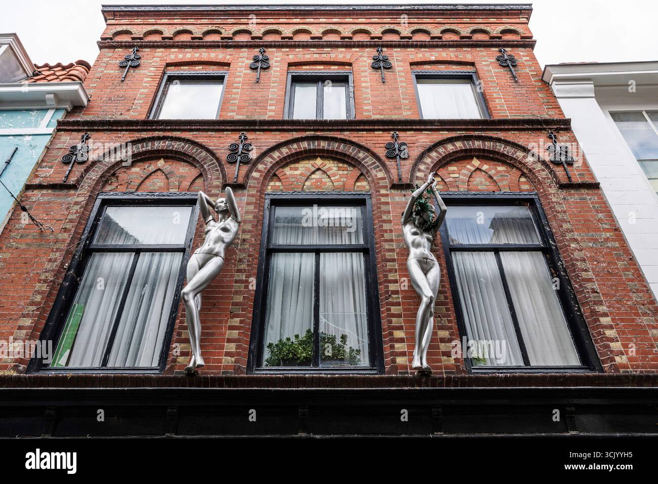 Figuren auf einem Haus im Stadtzentrum, Vlissingen, Walcheren, Zeeland, Niederlande. Figuren an einem Haus im Zentrum, Vlissingen, Walcheren, Zeeland, Stockfoto