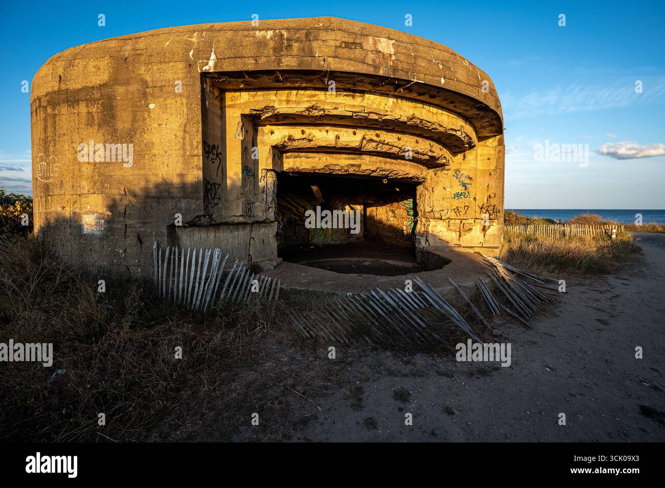 Atlantic Wall Gun Position in Gavres, Bretagne, Frankreich, beleuchtet von goldenem Sonnenuntergang, beleuchtet seine militärische Geschichte aus dem Zweiten Weltkrieg und die Küstenlandschaft Stockfoto Atlantic Wall Gun Position in Gavres, Bretagne, Frankreich, beleuchtet von goldenem Sonnenuntergang, beleuchtet seine militärische Geschichte aus dem Zweiten Weltkrieg und die Küstenlandschaft Stockfoto
