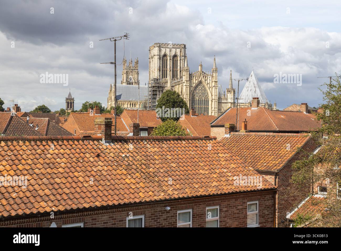 Blick über die rot gekachelten Dächer in York, England, in Richtung der berühmten gotischen architektonischen Pracht der York Minster Cathedral Stockfoto