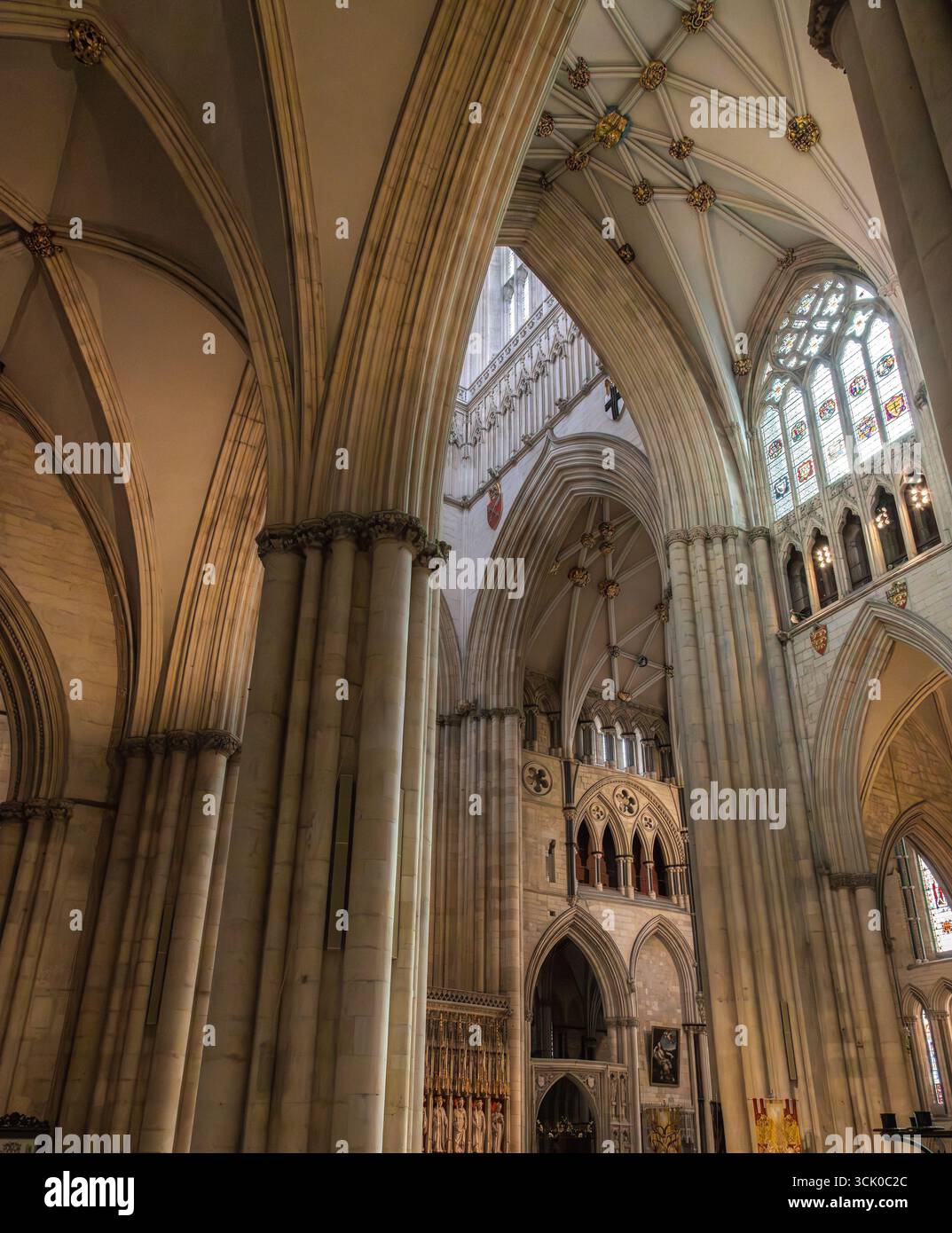 Das Innere der York Minster Cathedral in York zeigt Spitzbögen, Rippengewölbe, hohe Säulen und Buntglasfenster im gotischen Stil Stockfoto