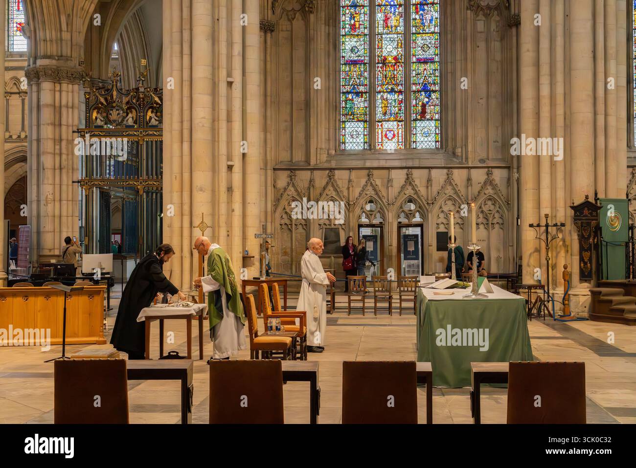 Das Innere der York Minster Cathedral in York, England, religiöser Gottesdienst am Altar mit Buntglasfenstern, Steinsäulen und gotischer Architektur Stockfoto