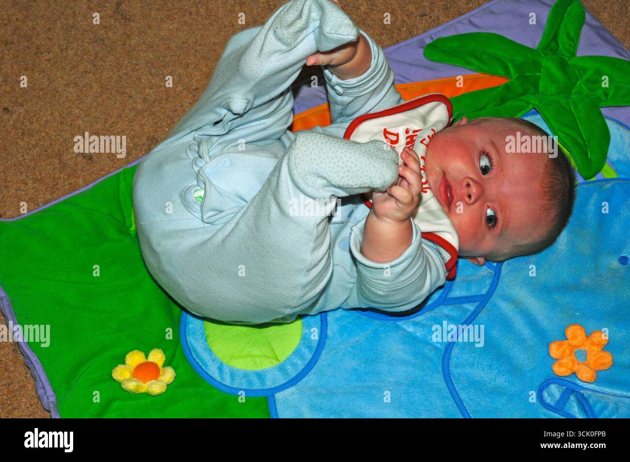 Junge, der auf Spielmatte spielt. Stockfoto