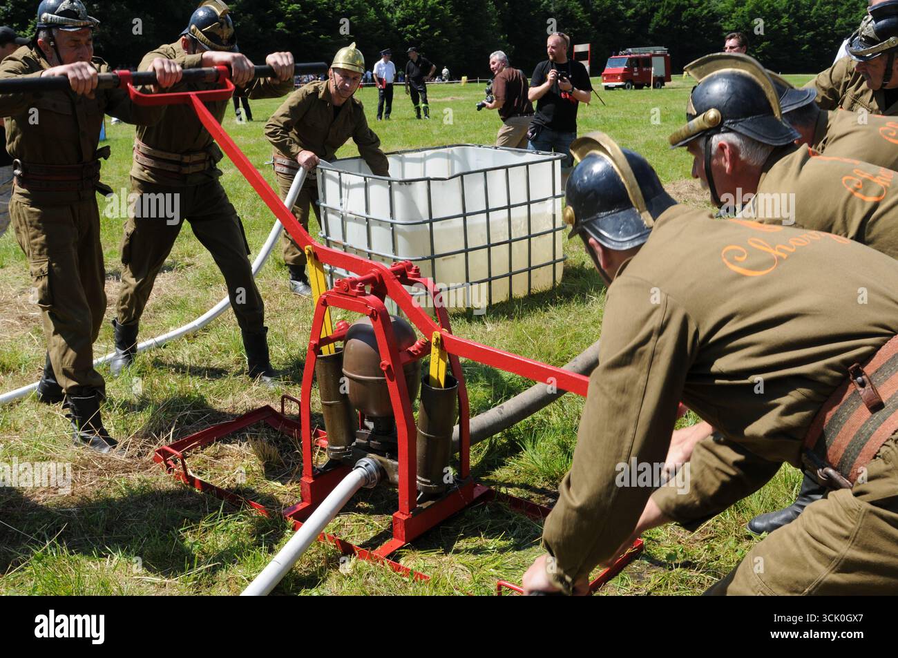 Feuerwehrleute in historischen Uniformen, die Handpumpen während des Feuerwehrwettbewerbs in Rudawka Rymanowska, Subkarpaten, Polen, betreiben Stockfoto