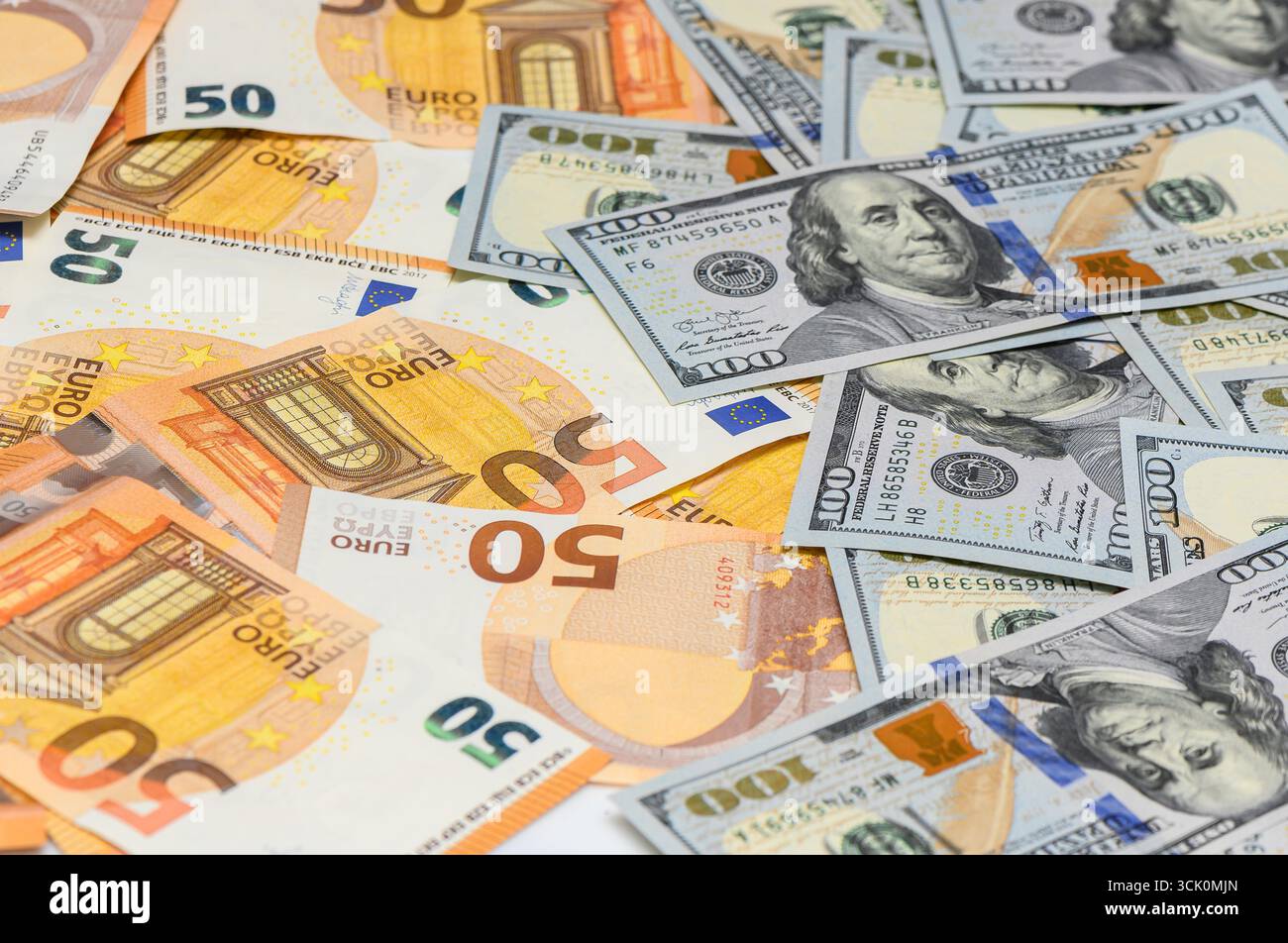 Geldhintergrund aus verstreuten 100 US-Dollar-Scheinen und 50 Euro-Scheine, Symbol für internationale Wirtschaft, Spareinlagen und Bankfinanzierung. Stockfoto