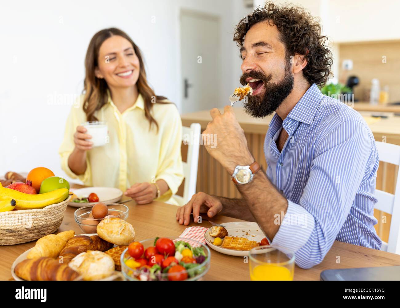 Mann und Frau haben ein nahrhaftes Frühstück mit Früchten und gemeinsame Gespräche in sonniger und einladender Atmosphäre Stockfoto