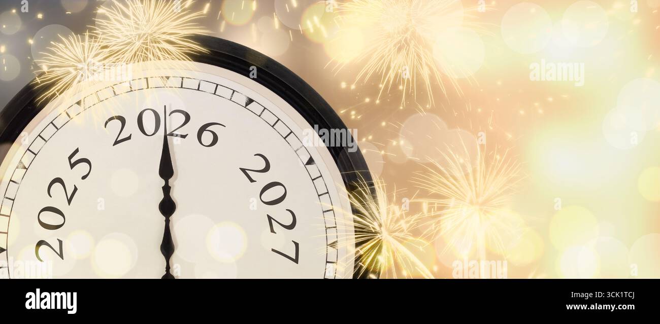 Neujahrsuhr 2026 auf Gold funkelndem Hintergrund mit Feuerwerk und leuchtenden Lichtern. Stockfoto