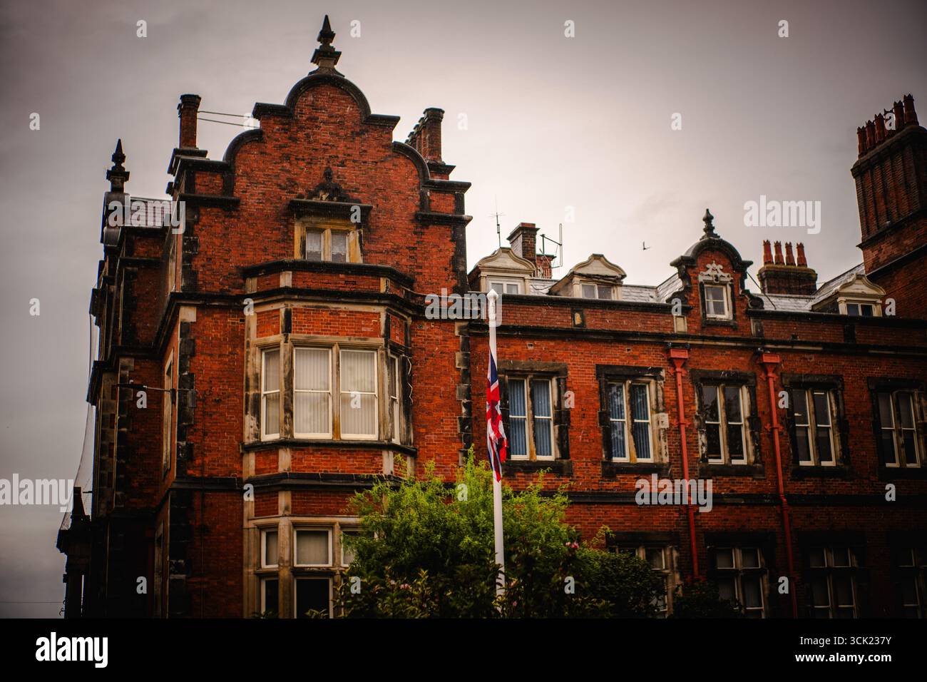 Historisches Gebäude aus rotem Backstein mit Union Jack Flagge Stockfoto