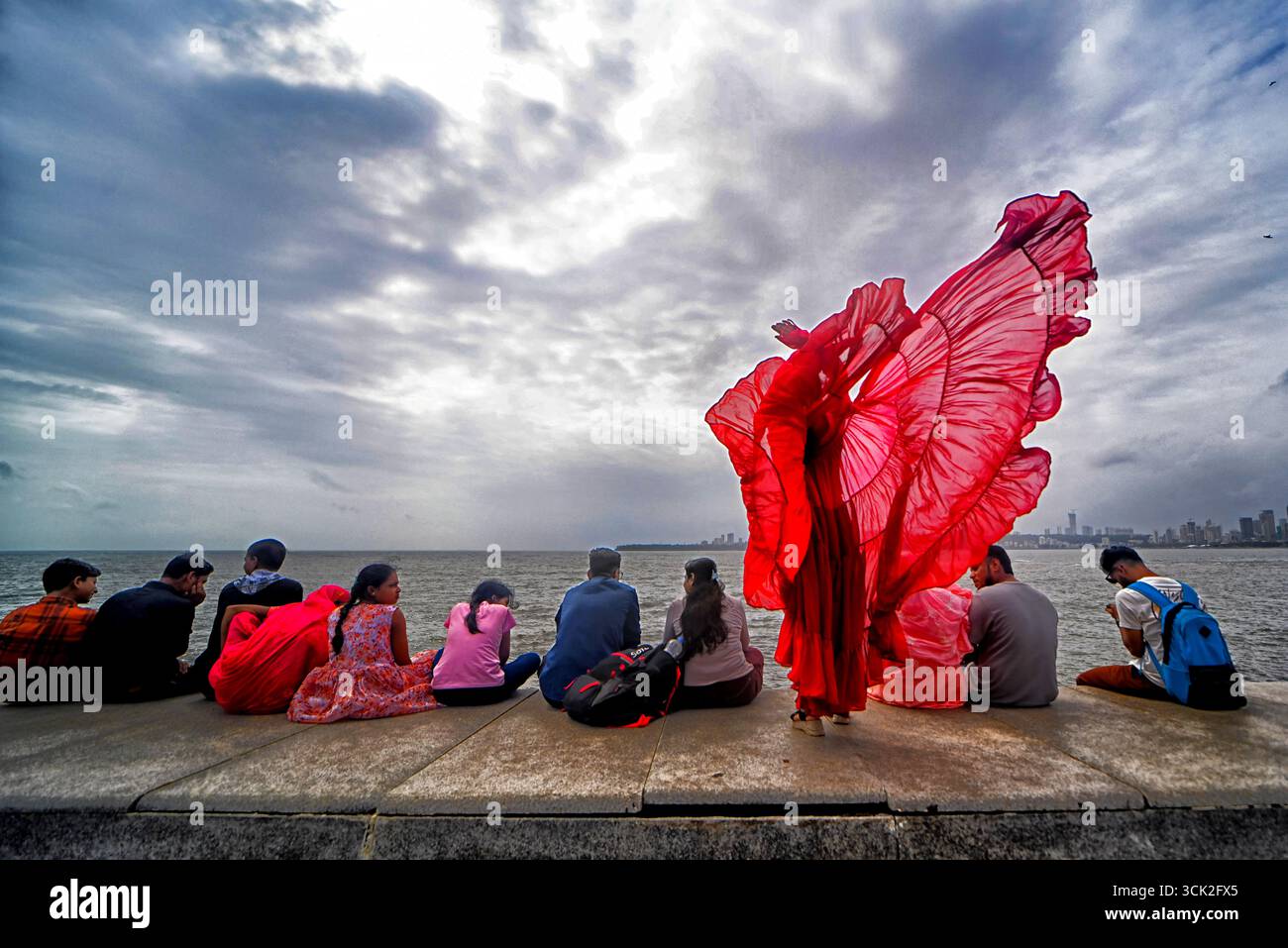 Mumbai, Indien. September 2025. Ein Model (Rohini) posiert für ein dokumentarisches Modeshooting am berühmten Marine Drive von Mumbai. Das Projekt dokumentiert die beliebte Reiseziel-Initiative, die während der Nachmonsunsaison von Creative Art Solution, Einem registrierten Photography Club of India, für lokale Touristen konzipiert wurde. Der Marine Drive ist eine 3,6 km lange Promenade im Art déco-Stil in Mumbai, die auf einer natürlichen Bucht erbaut wurde und Nariman Point mit Chowpatty Beach verbindet Stockfoto