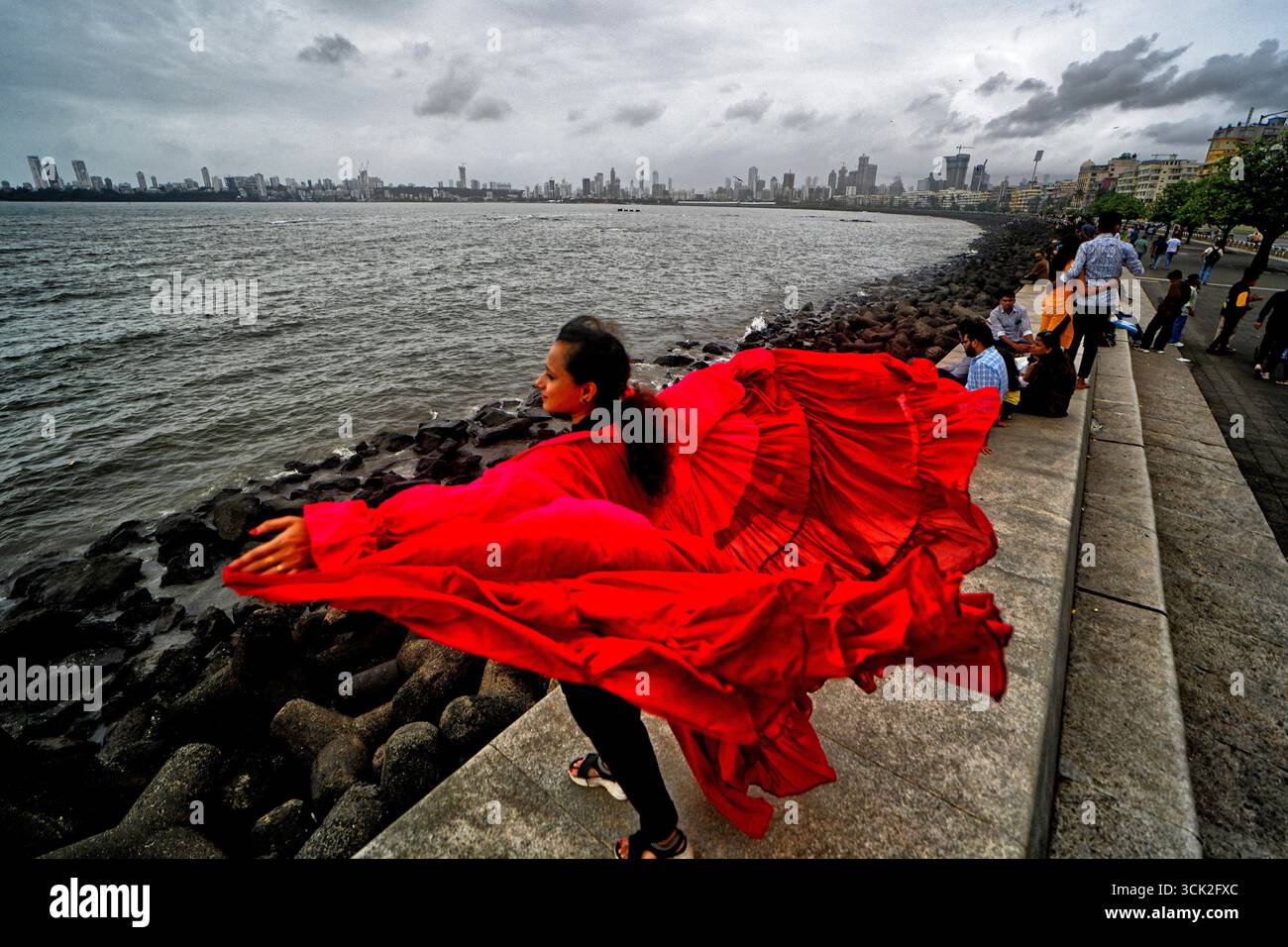 Mumbai, Indien. September 2025. Ein Model (Rohini) posiert für ein dokumentarisches Modeshooting am berühmten Marine Drive von Mumbai. Das Projekt dokumentiert die beliebte Reiseziel-Initiative, die während der Nachmonsunsaison von Creative Art Solution, Einem registrierten Photography Club of India, für lokale Touristen konzipiert wurde. Der Marine Drive ist eine 3,6 km lange Promenade im Art déco-Stil in Mumbai, die auf einer natürlichen Bucht erbaut wurde und Nariman Point mit Chowpatty Beach verbindet Stockfoto