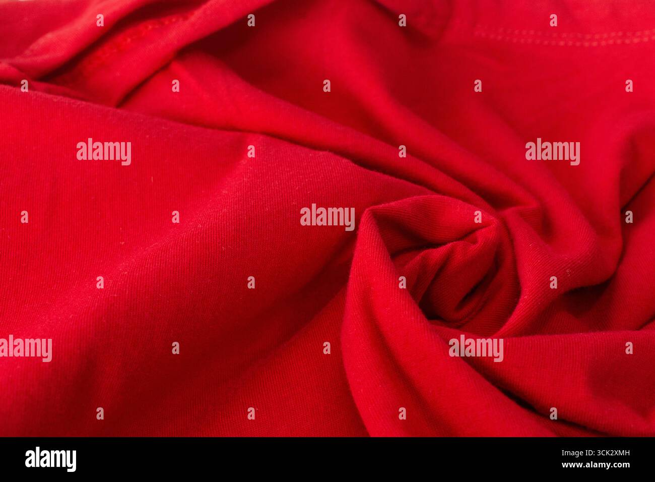 Close-up Rote, verdrehte Stoffstruktur, zerknitterter roter Stoffhintergrund. Stockfoto