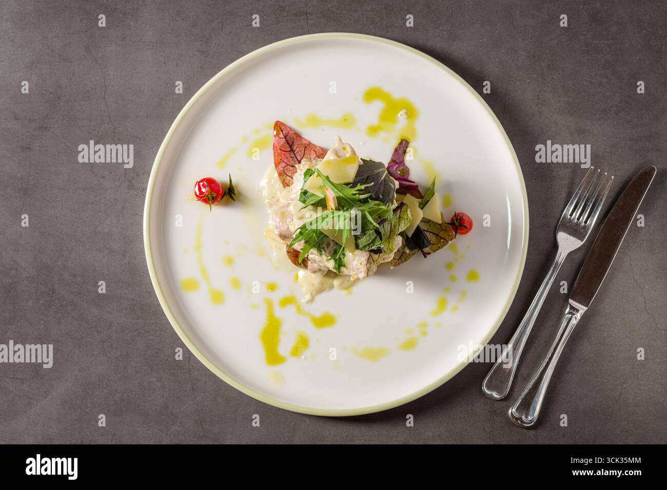 Gegrilltes Hühnchen mit Pilzen und Sahnesauce auf einem dunklen Steintisch Stockfoto