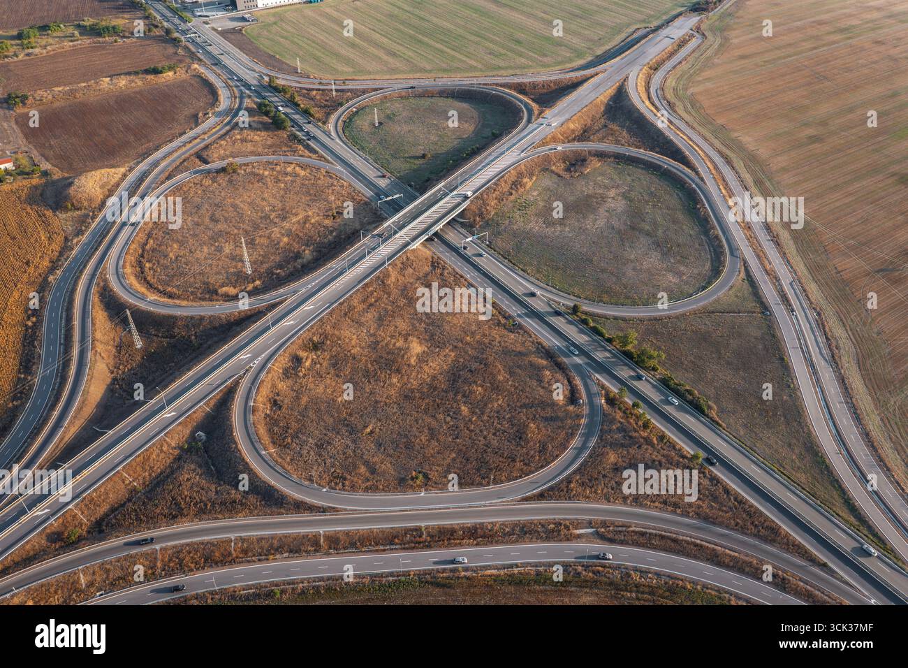 Blick aus der Vogelperspektive auf die wunderschöne Autobahnkreuzung in Kleeform an Sommertagen. Logistikkonzept Stockfoto