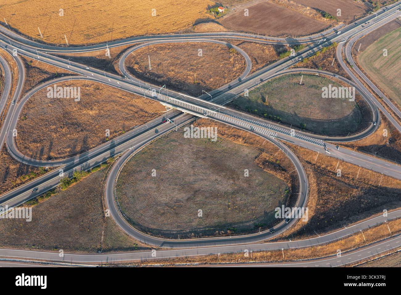 Blick aus der Vogelperspektive auf die wunderschöne Autobahnkreuzung in Kleeform an Sommertagen. Logistikkonzept Stockfoto