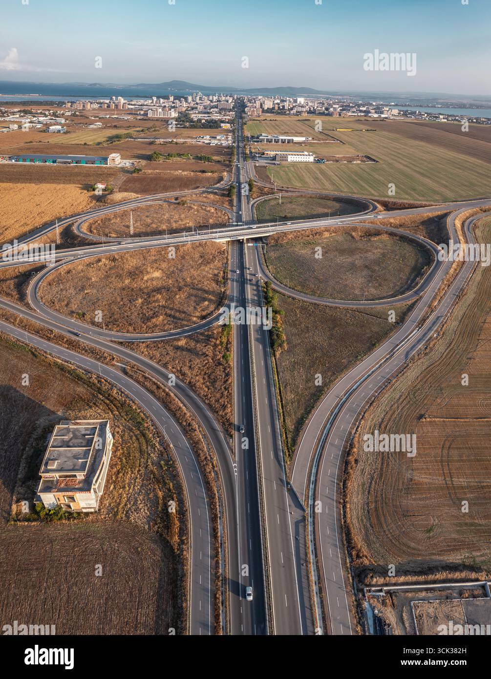 Blick aus der Vogelperspektive auf die wunderschöne Autobahnkreuzung in Kleeform an Sommertagen. Logistikkonzept Stockfoto