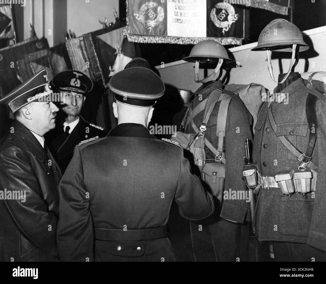 Adolf Hitler untersucht in Begleitung von Offizieren englische und belgische Uniformen und französische Banner, 1941 Stockfoto