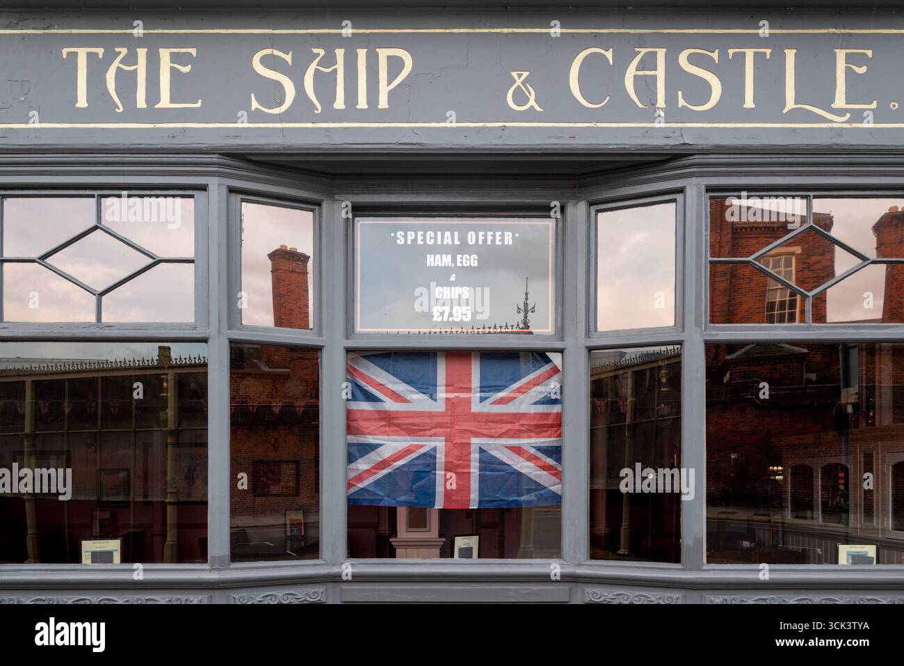 Pub-Fenster in England mit einem Union Jack und heutigem Special mit Schinken, Ei und Pommes frites. Klassisches Bild der englischen Kultur. Stockfoto