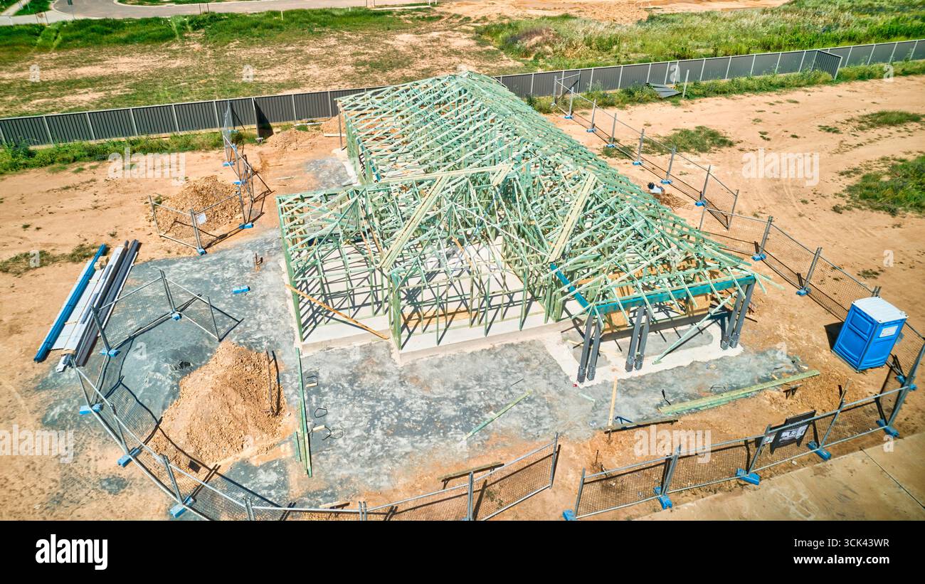 Die Hausrahmenkonstruktion umfasst komplette Holzdachbinder und Grünmauern in Bearbeitung Stockfoto