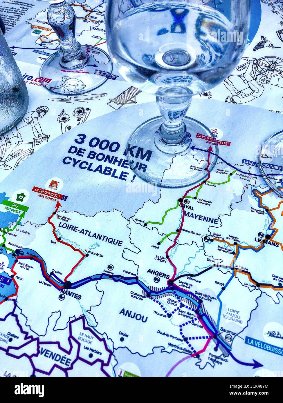 Bistrotisch im Freien geschützt durch Fahrradkarte mit 3.000 km Routen in Westfrankreich - Angers, Maine-et-Loire (49), Frankreich. Stockfoto