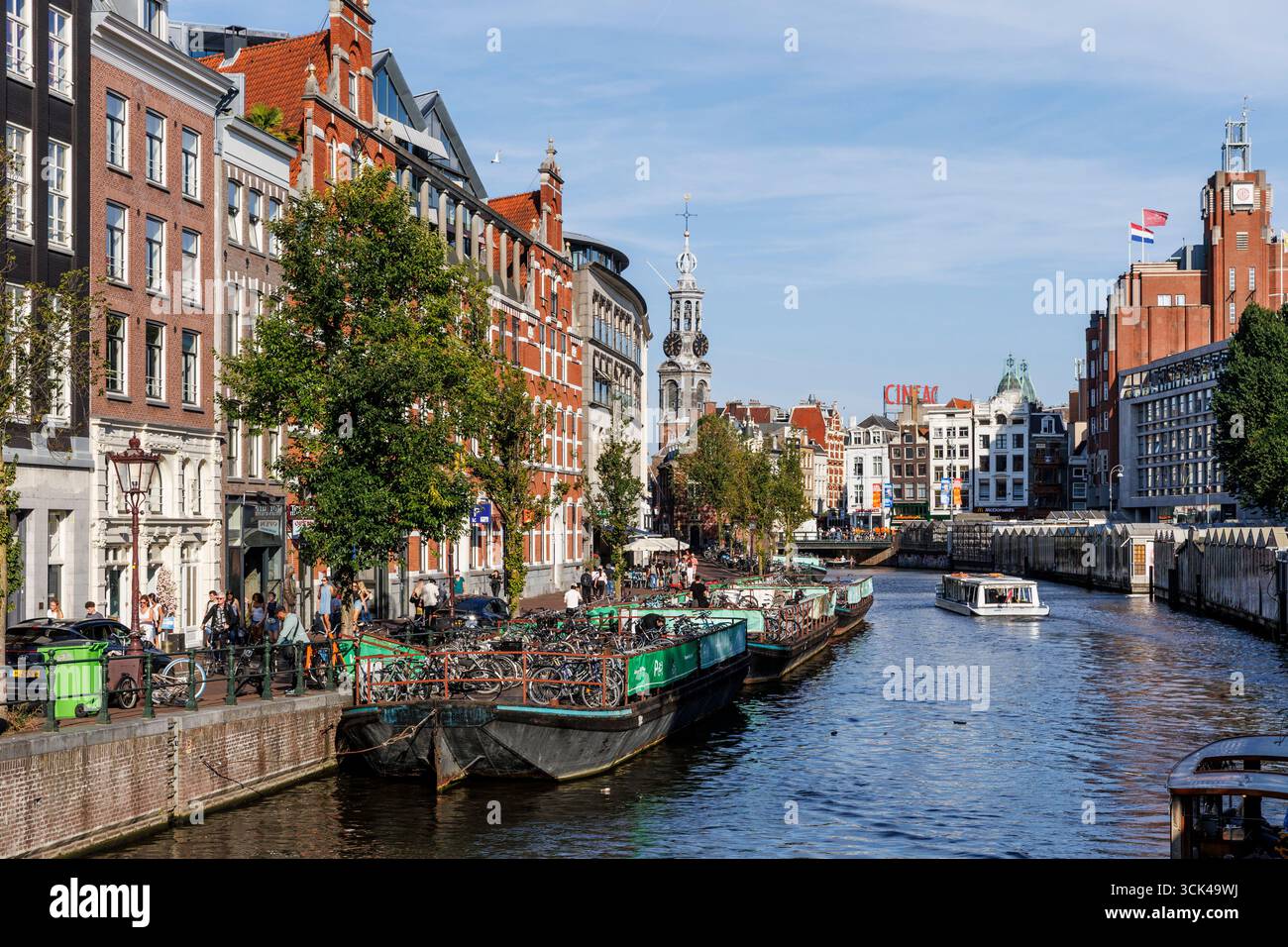 Blick über den Singel-Kanal zum Munttoren-Turm im Stadtzentrum, auf der rechten Seite die Stände des Blumenmarktes, Amsterdam, Niederlande. Blick uber Stockfoto