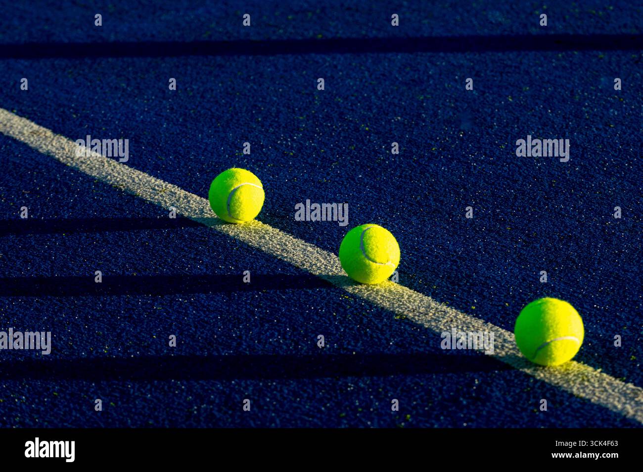 Gelbe Padelkugeln mit langen dramatischen Schatten, Abendlicht Stockfoto