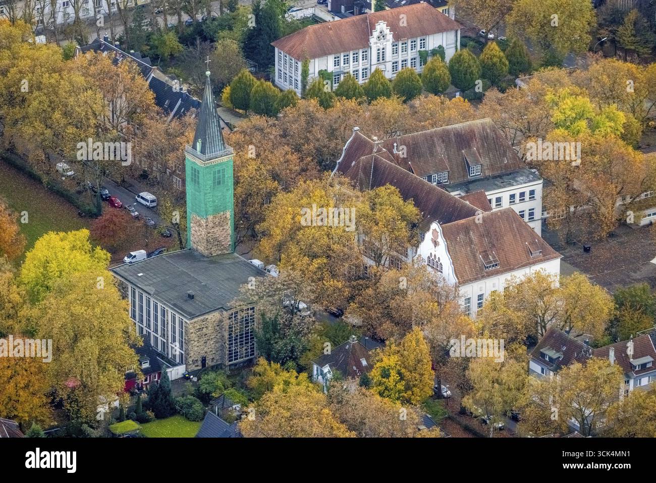 Aus der Vogelperspektive, St. Paul's Church mit überdachtem Kirchturm, Carl-Friedrich-Gauß-Gymnasium und Außengebäude, umgeben von herbstlichen Laubbäumen Stockfoto