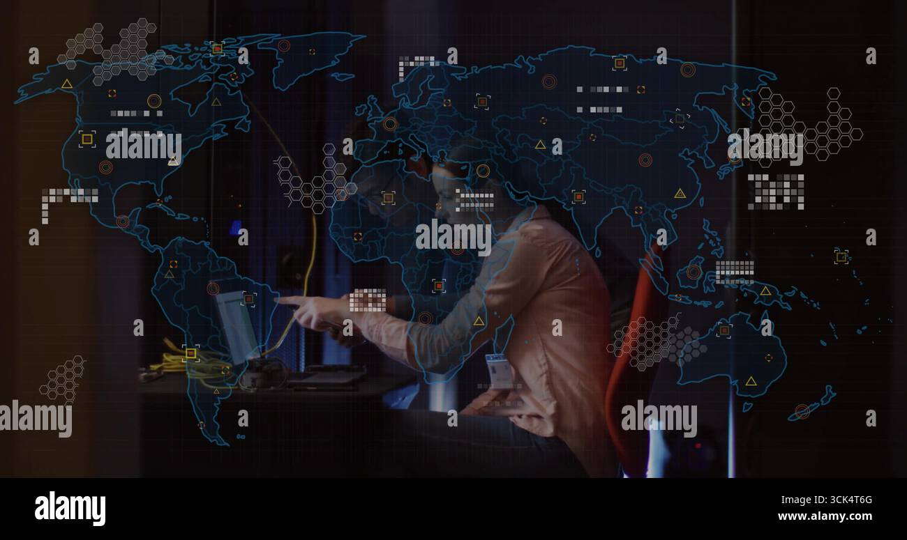 Zeigende Frau im Blazer, die Kollegen bei der Analyse auf einem Laptop mit Kartenüberlagerung im Kontrollraum anleitet Stockfoto