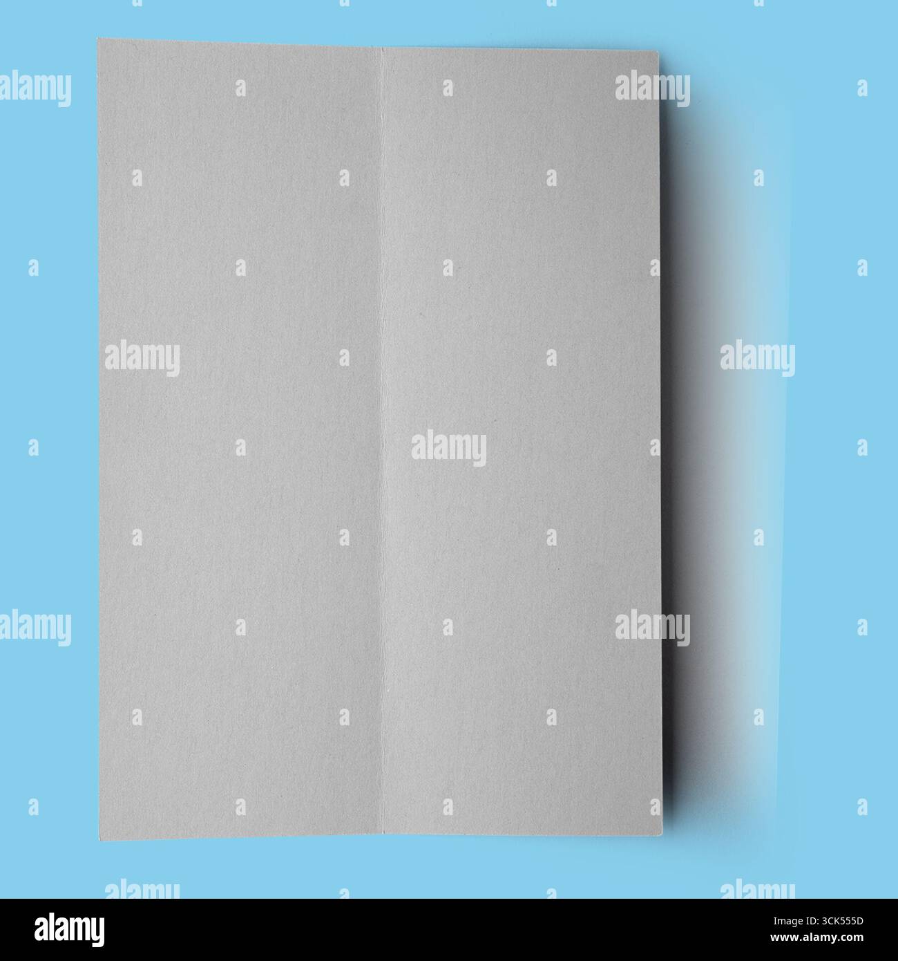 Ein leeres, gefaltetes graues Blatt Papier, das auf das Potenzial für Schreiben oder Design hinweist. Stockfoto
