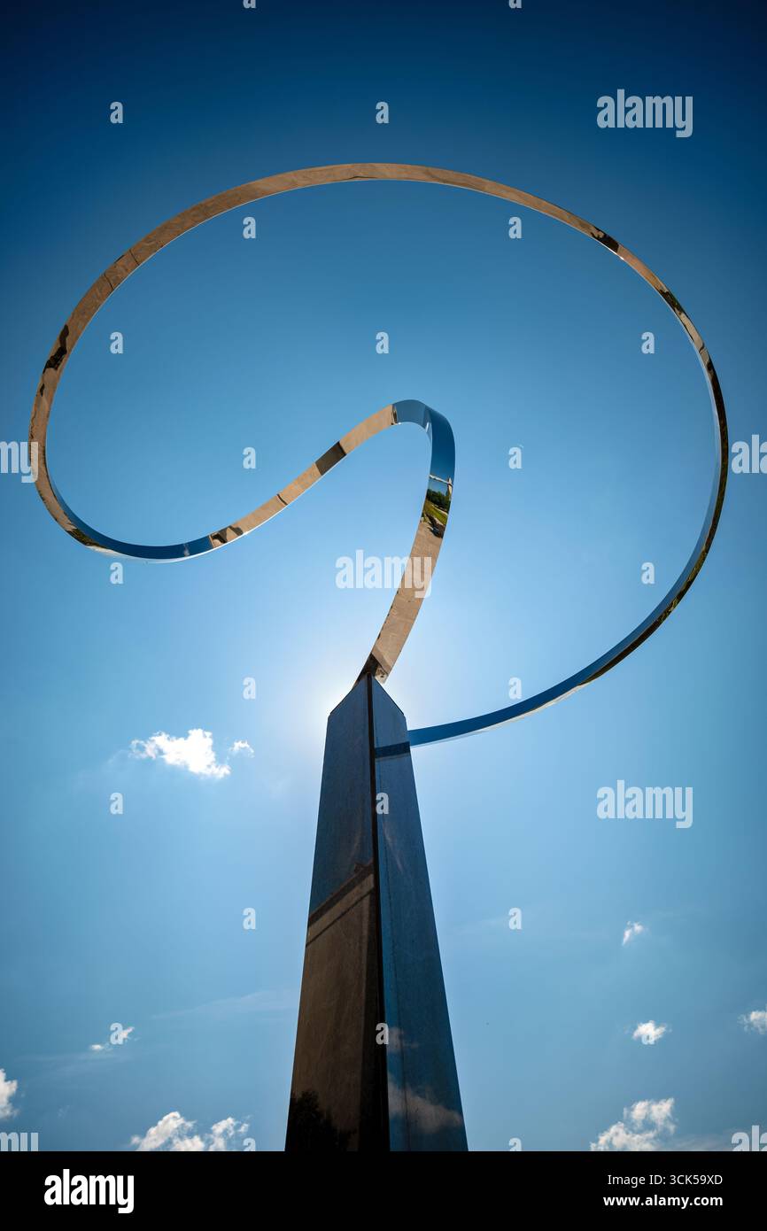 Infinity Sculpture Smithsonian National Museum of American History Washington DC // WASHINGTON DC – die Infinity Sculpture, ein abstraktes Kunstwerk von José de Rivera, ist eine prominente Installation moderner Kunst auf dem Gelände des Smithsonian National Museum of American History. Die Skulptur hat eine polierte, bandartige Form, die sich windet und sich gegen den Himmel schmiegt und von einer dunklen, Obelisken-ähnlichen Basis unterstützt wird. Seine reflektierende Oberfläche spiegelt die Umgebung wider, einschließlich Himmel und Wolken. Das Smithsonian National Museum of American History widmet sich der Bewahrung und Präsentation der Stockfoto