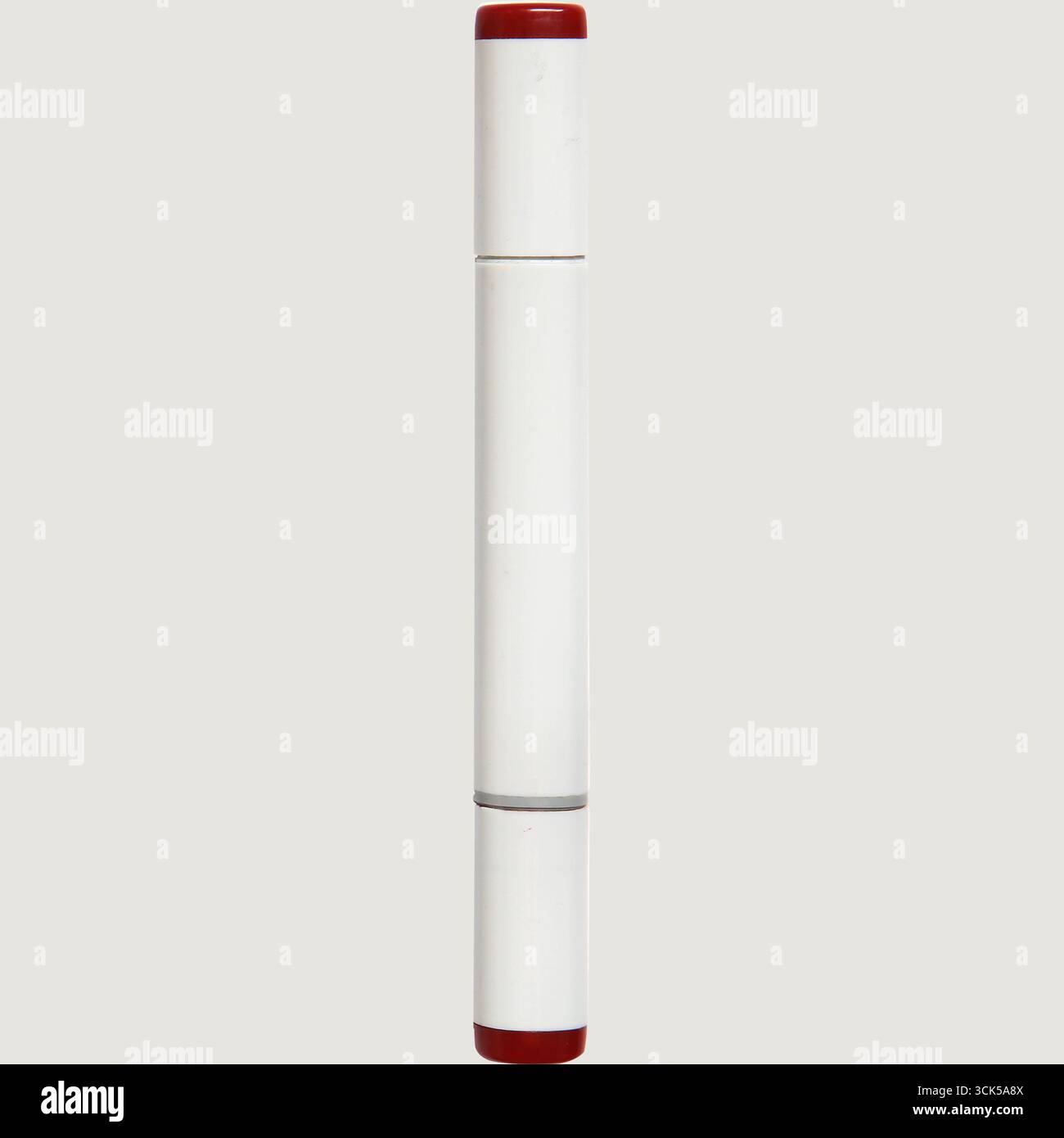 Ein zylindrisches Objekt mit einem weißen Körper und roten Enden, wahrscheinlich ein Marker oder Stift, der zum Schreiben oder Zeichnen verwendet wird. Stockfoto