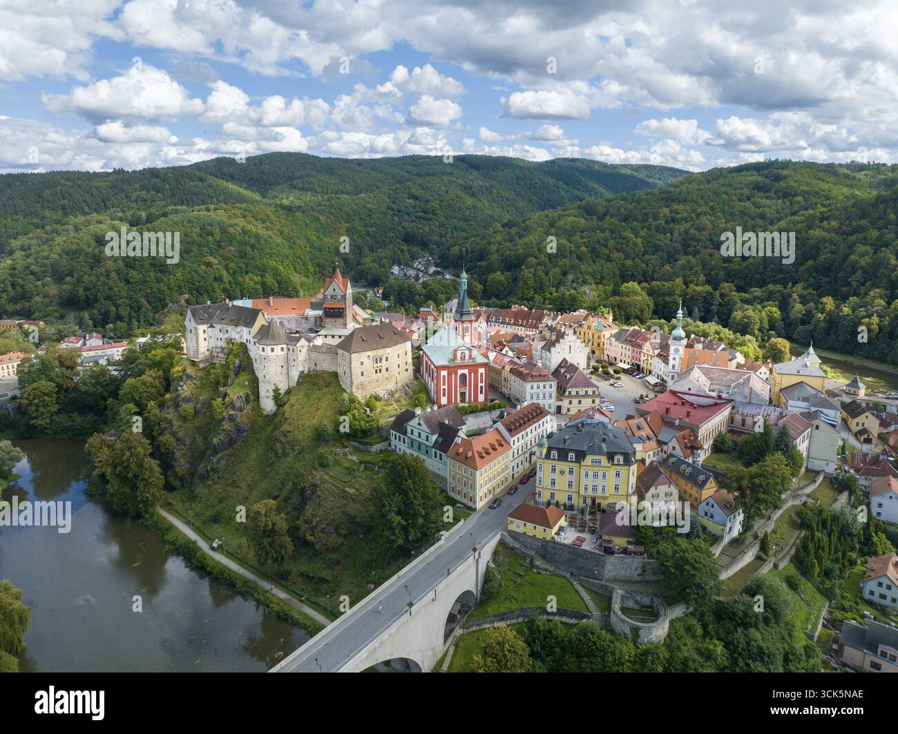 Mittelalterliche Burg auf einem Hügel, umgeben von malerischer Landschaft und Fluss, bei hellem bewölktem Wetter, Schloss Elbogen, Loket, Loket Dorf, Okres Sokolo Stockfoto