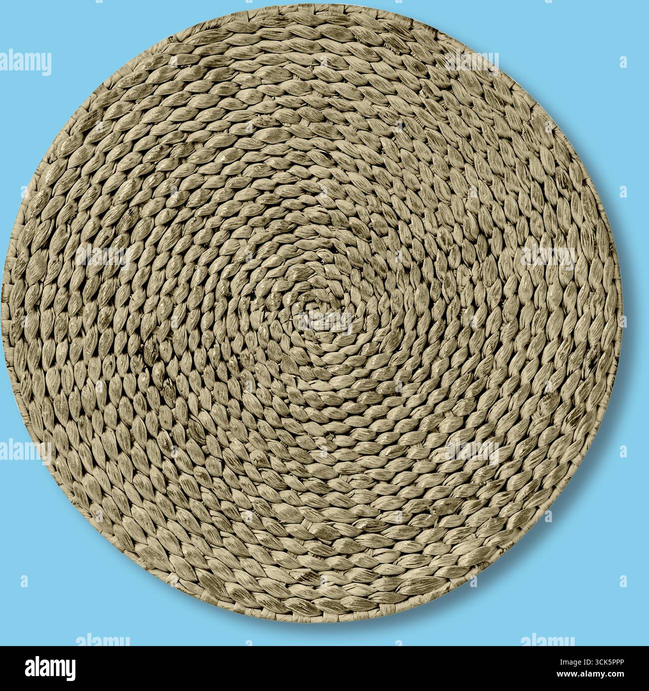 Eine runde gewebte Matte in einem neutralen Ton, geeignet für Wohnkultur oder als dekorativer Akzent. Stockfoto