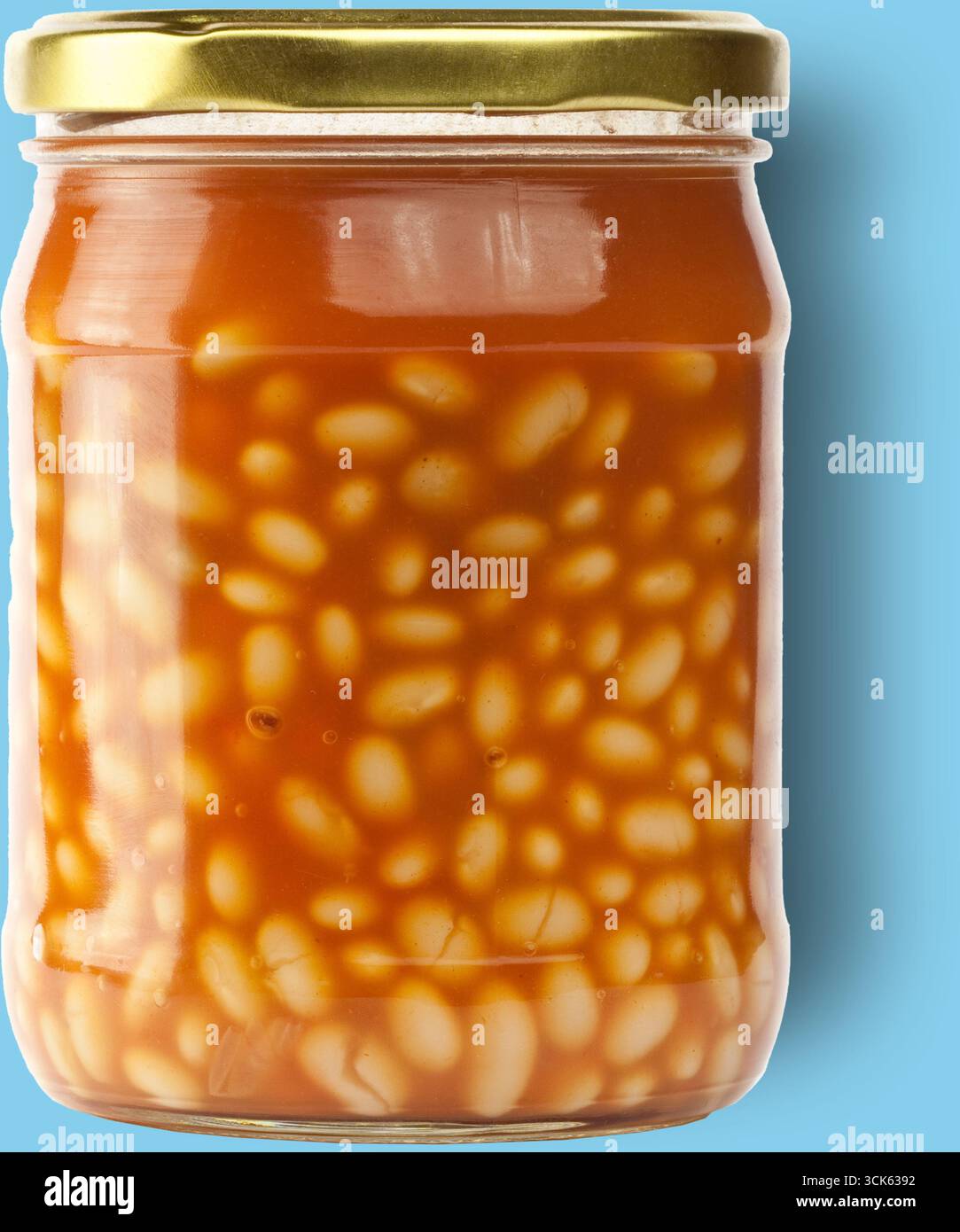 Ein mit weißen Bohnen gefülltes Glas in einer reichhaltigen Tomatensauce, das in der Regel als praktische Option verwendet wird. Stockfoto