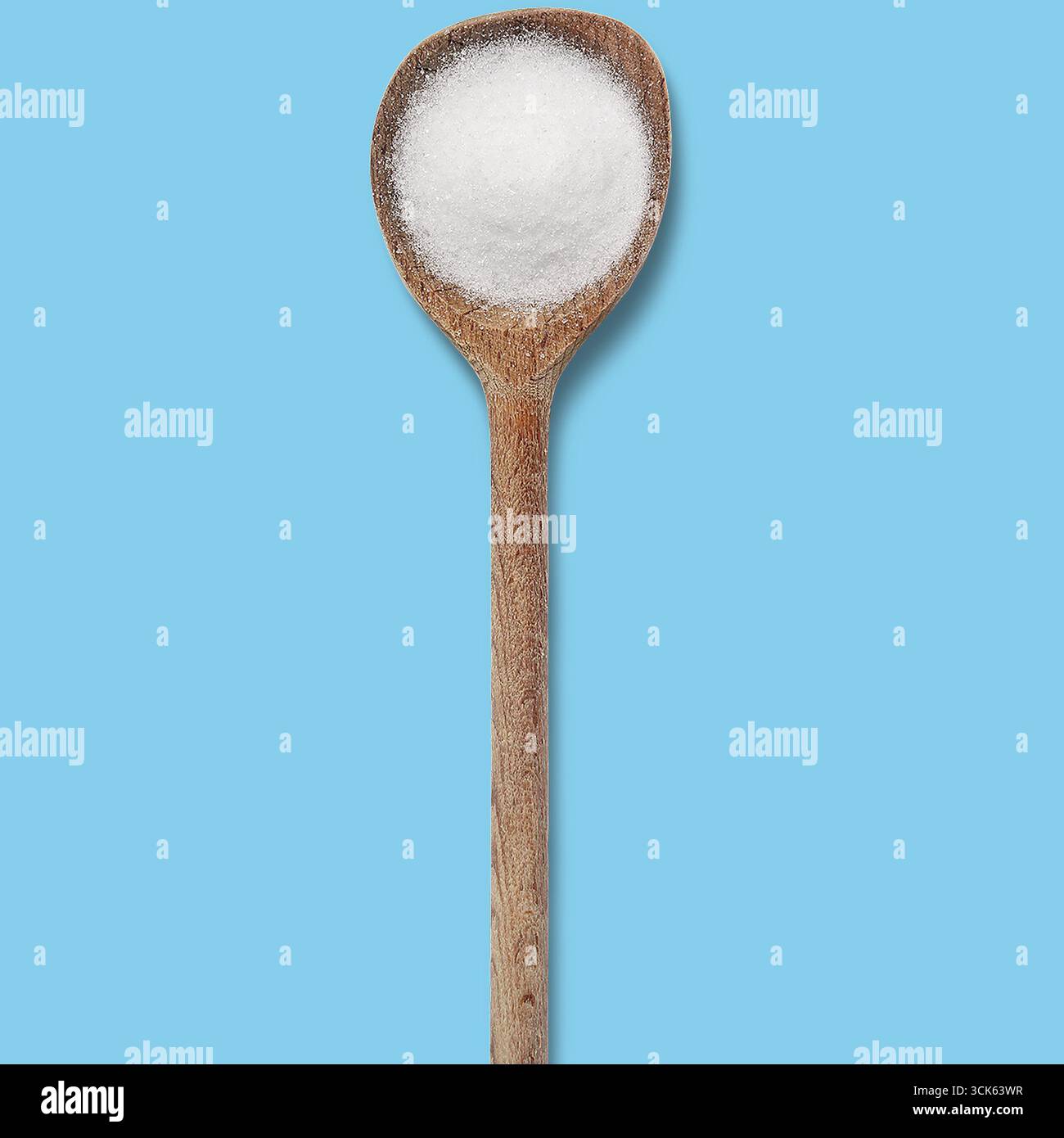 Ein mit weißem Salz gefüllter Holzlöffel, der häufig zum Kochen und Würzen von Gerichten verwendet wird. Stockfoto