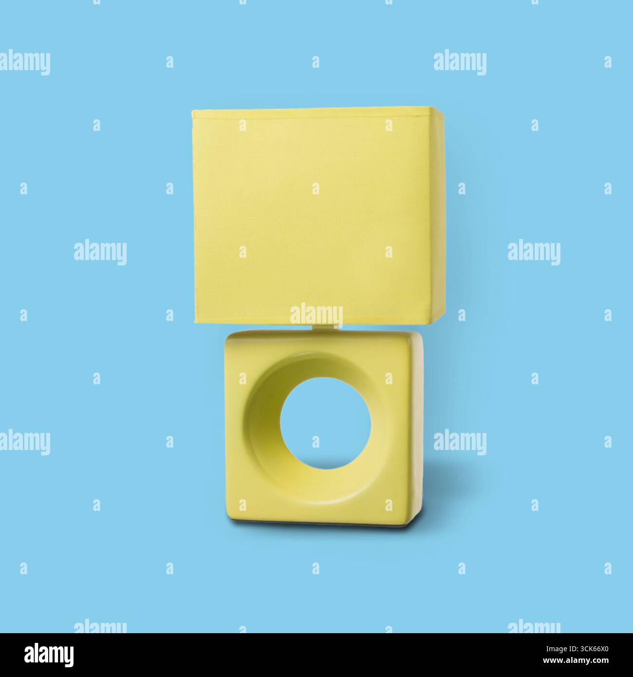 Eine minimalistische Skulptur aus einem gelben Würfel und einem runden Sockel, die moderne Design-Ästhetik zeigt. Stockfoto