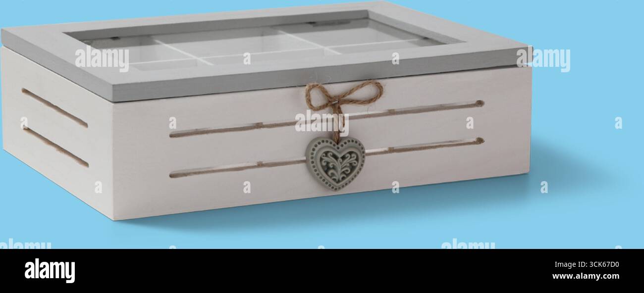 Eine dekorative Aufbewahrungsbox mit Glasdeckel und herzförmiger Verzierung zur Organisation kleiner Gegenstände. Stockfoto