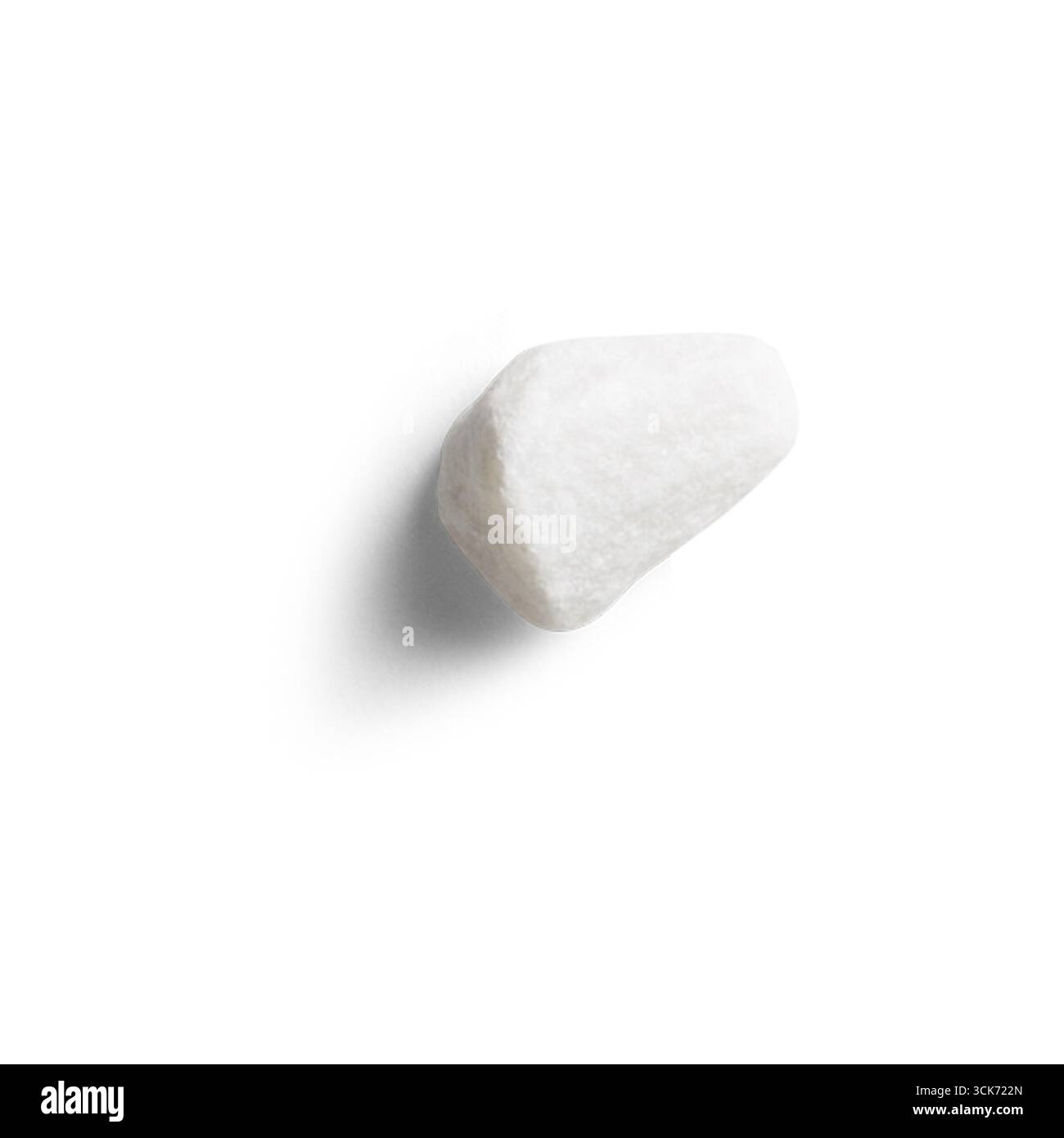 Ein einzelner weißer Stein auf einem glatten Hintergrund, der seine glatte Textur und natürliche Form zeigt. Stockfoto